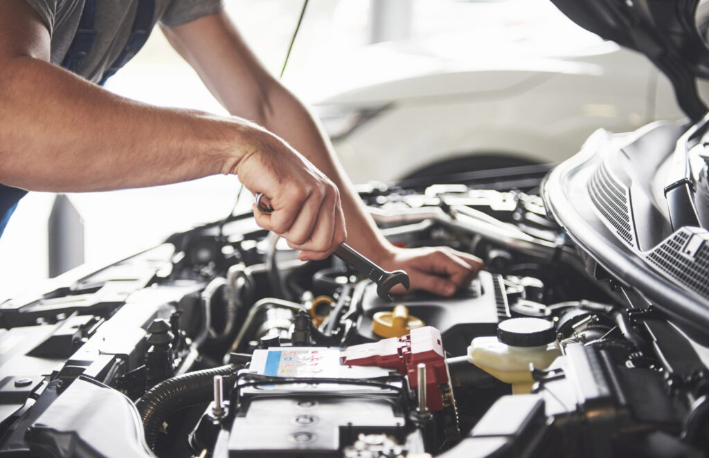 Car inspection service: A man checking the bonnet.